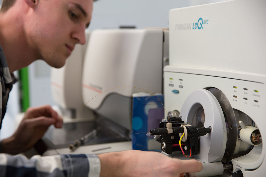 A forensic science student working with equipment in a lab