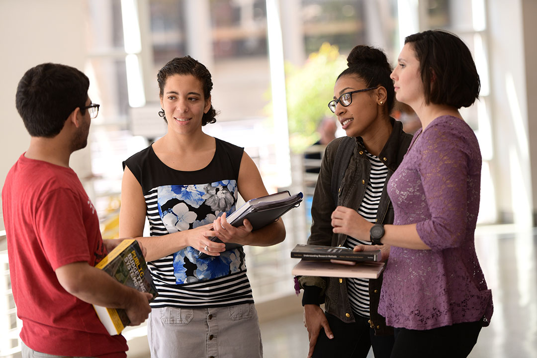 A group of TSPPPA students holding books and talking