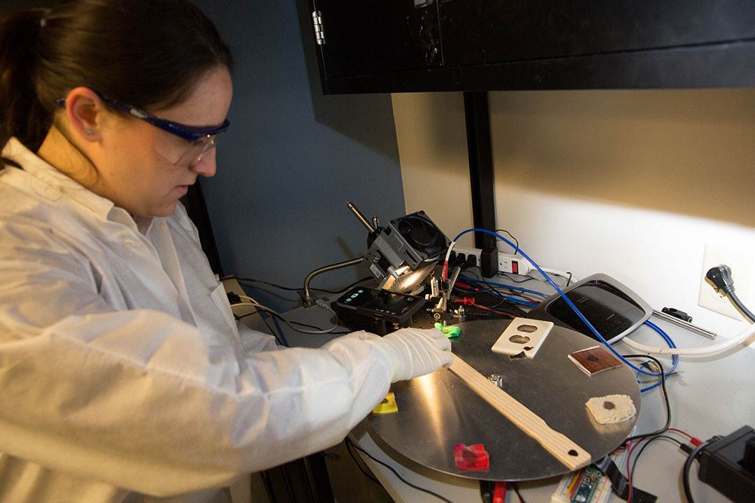 Student in a lab analyzing evidence on different surfaces