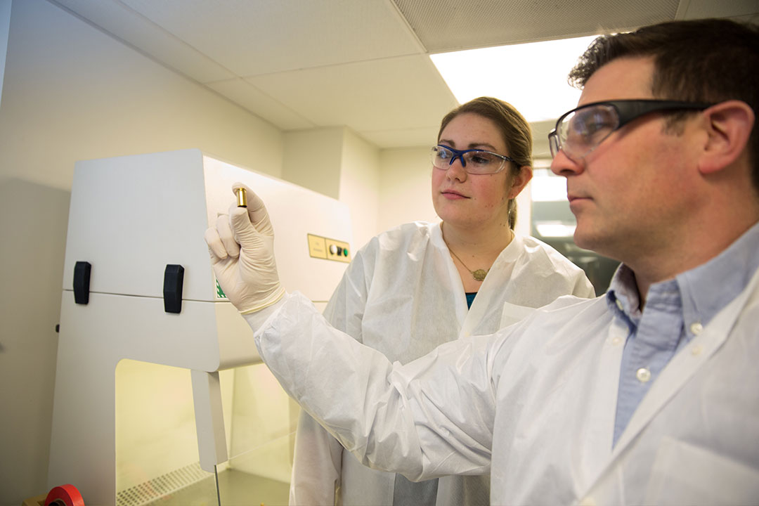 Professor Podini looking at a bullet casing with a student in a forensic sciences laboratory